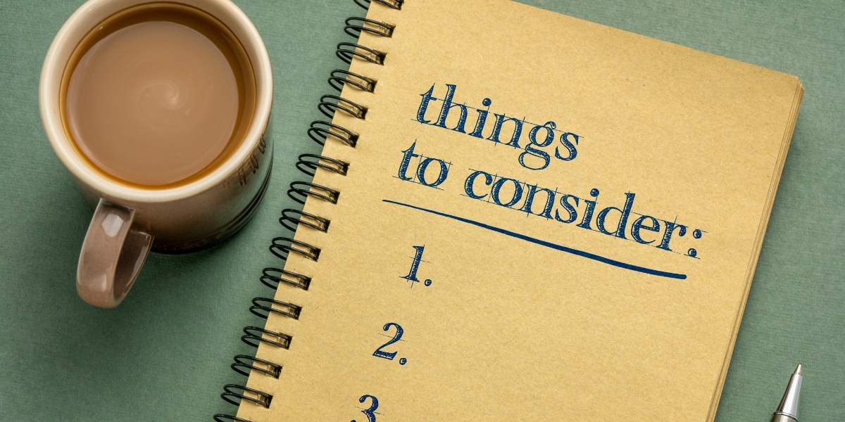 A notepad with the text "things to consider" written on it and a cup of coffee next to it