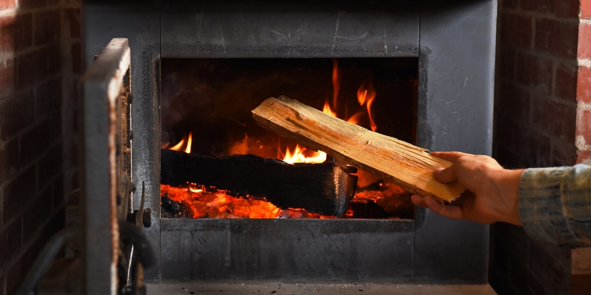 Wood stove in traditional brick fireplace