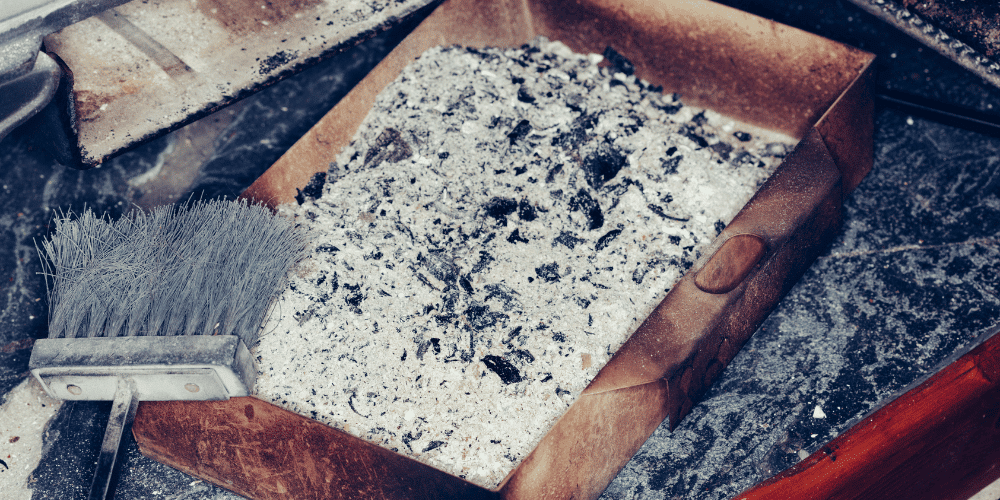 A fireplace tray filled with soot and ash