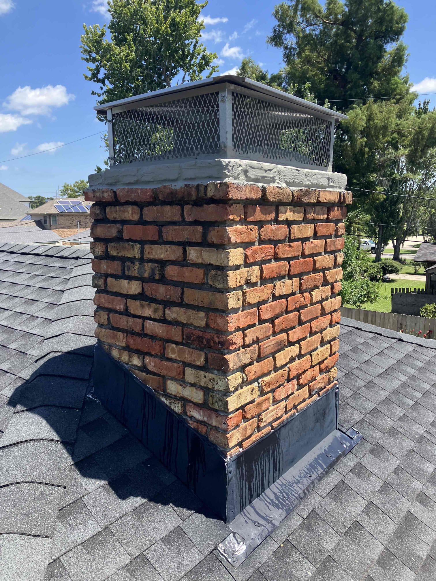 A detailed chimney safety inspection focusing on the masonry and chimney cap of a brick home