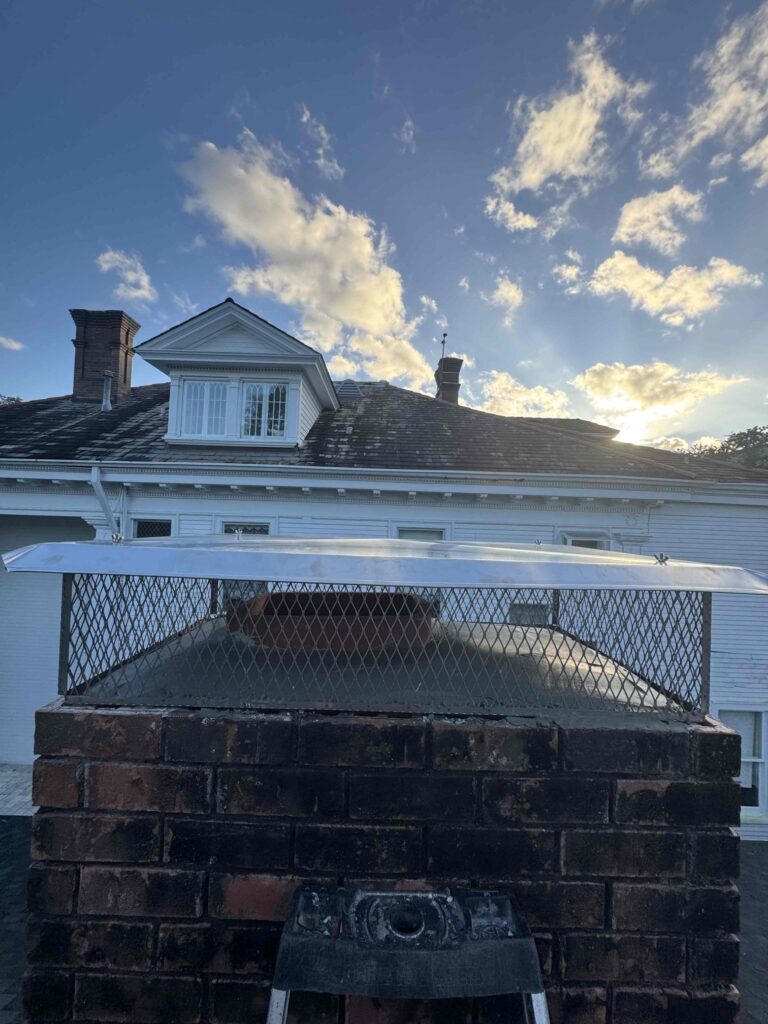 A certified technician performing expert chimney services in Mandeville, LA on a traditional brick chimney